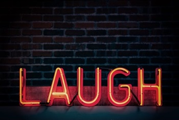 neon sign that reads - laugh